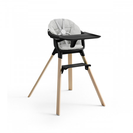 Cojín trona Clikk de Stokke, trona de color black y patas de madera.