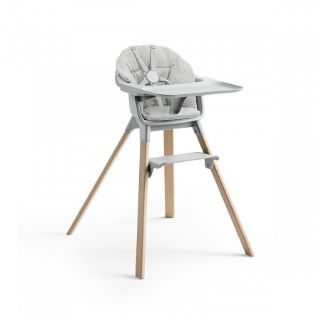 Cojín trona Clikk de Stokke, trona de color gris nube y patas de madera.