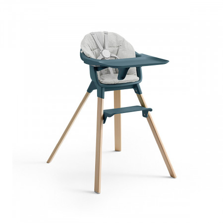 Cojín trona Clikk de Stokke, trona de color fjord blue y patas de madera.