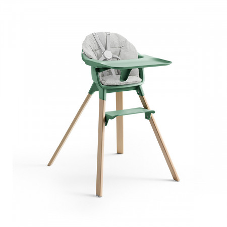 Cojín trona Clikk de Stokke, trona de color verde trebol y patas de madera.