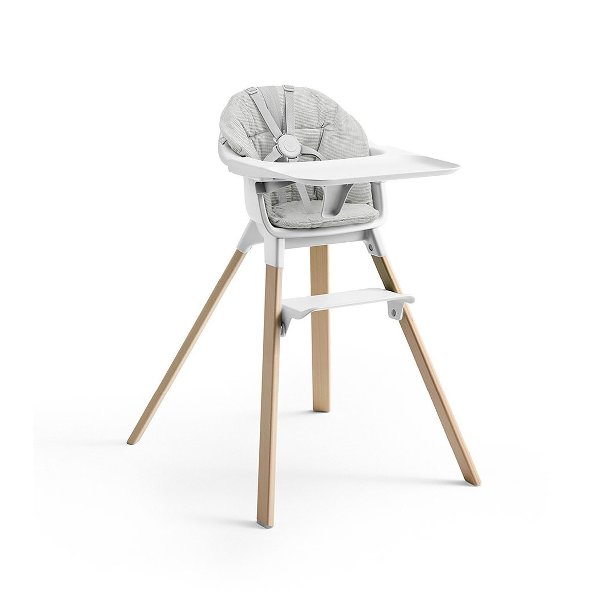 Cojín trona Clikk de Stokke, trona de color blanco y patas de madera.