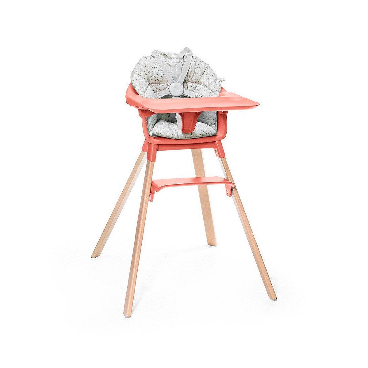 Cojín trona Clikk de Stokke, trona de color soral soleado y patas de madera.