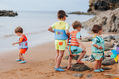 niños jugando en la playa llevando el chaleco flotador BTBOX