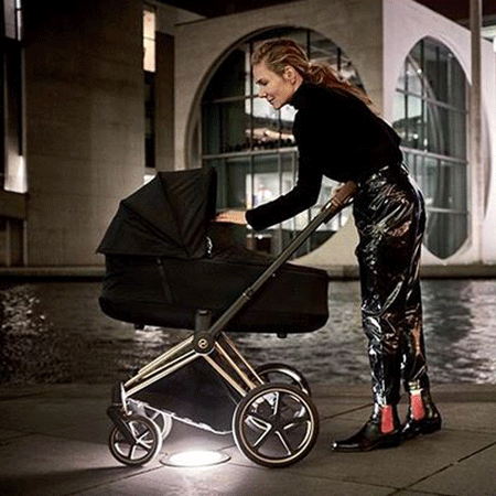 Mujer paseando a su bebé con un cochecito de dos piezas