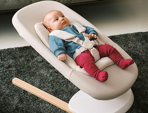 niño tumbado en la hamaca y balancín yoga de stokke