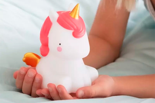 lámpara infantil de little lovely con forma de unicornio en manos de niña