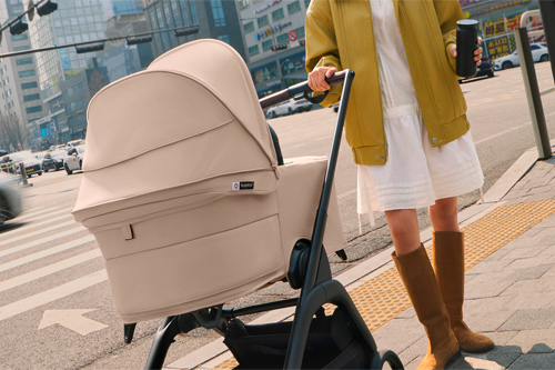 madre en la ciudad sujetando el capazo del cochecito Bugaboo Dragonfly Plus