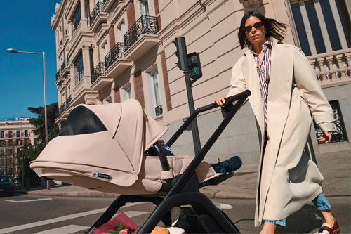 madre paseando por la ciudad con el cochecito Dragonfly Plus de Bugaboo con capota de color desert taupe