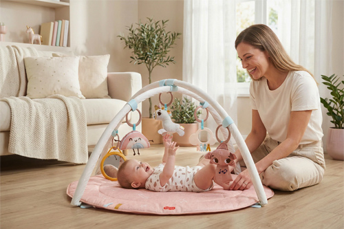 mamá viendo a su hija interactuando con el gimnasio para bebés Unicorn Wonderlands de Tiny Love