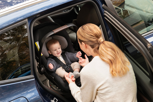 mamá sacando a su hijo de vehículo que va sentado en la silla de coche Nuna Arra Flex