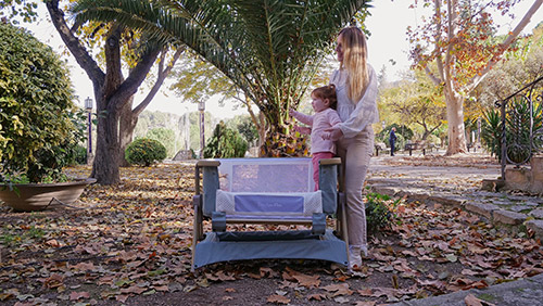 mamá e hija en el parque con la minicuna colecho Flex de BigToes