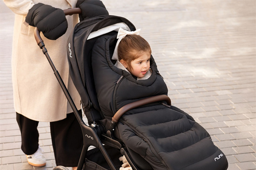 niña en silla de paseo Triv LX de Nuna con el saco de invierno