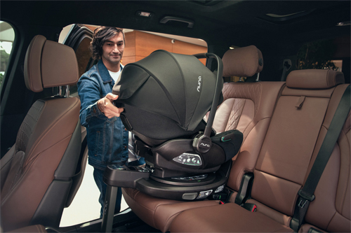 padre colocando la silla de coche en la base isofix CURV de Nuna