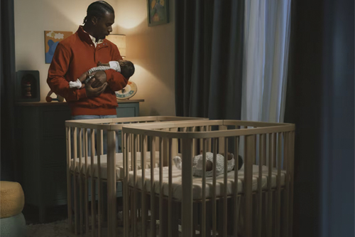 padre durmiendo a bebé frente a la minicuna Stokke Nighti MINI