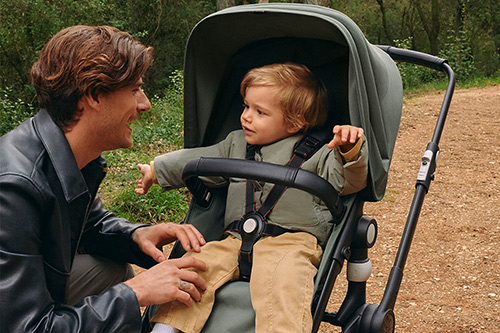 padre e hijo sentado en el cochecito bugaboo fox cub