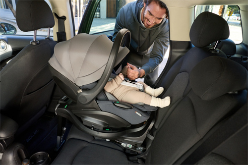 padre colocando en el interior del vehículo a su hijo en la silla de coche Darwin de Inglesina