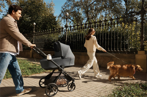 padres paseando con el perro y con el carrito Muum de Jané en día soleado