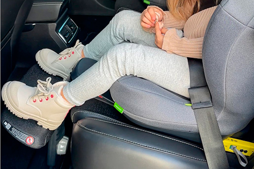 niña con reposapiés swandoo para silla de coche
