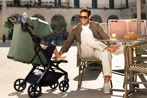 padre con la silla de paseo nubi 3 de kinderkraft en terraza