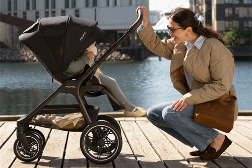 madre con hijo en la silla de paseo Triv LX de Nuna en día soleado