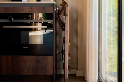 trona evolutiva Klapp de KAOS plegada en salón de casa